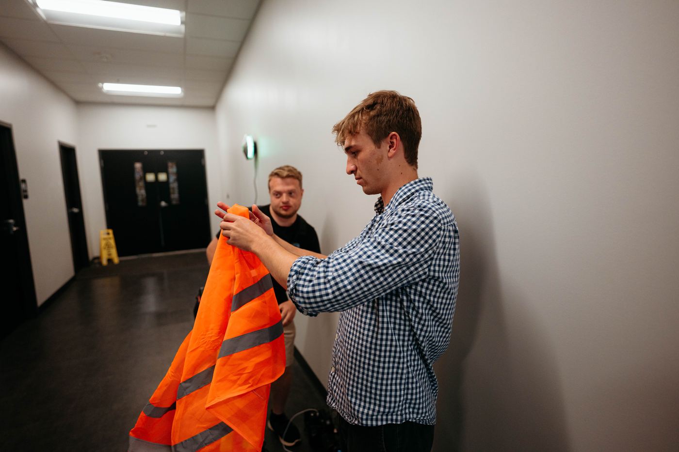 Crew pulling on safety vests in a hallway before going onto the floor
