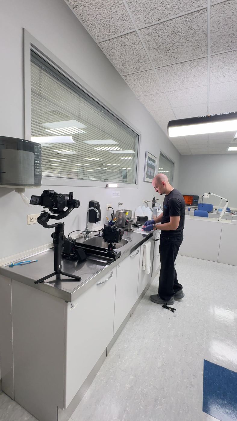 Technician at a steel counter beside a camera on a slider and a gimbal