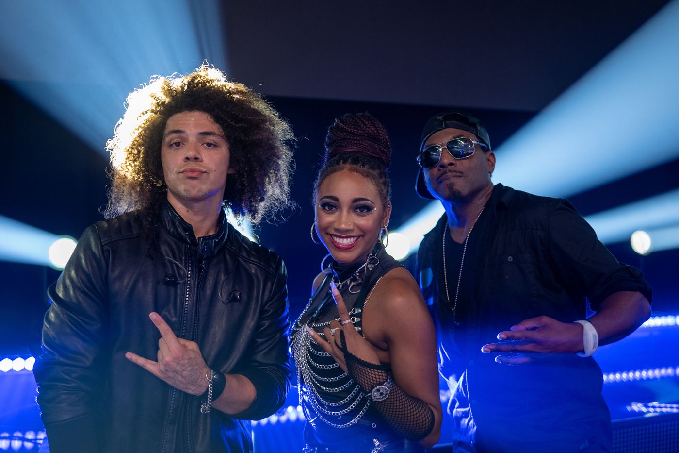 Three members of the band Liquid Blue posing under blue stage lights