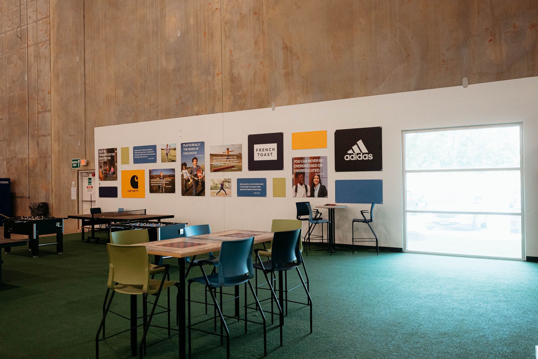 An employee break area with tables, chairs and brand posters on the wall