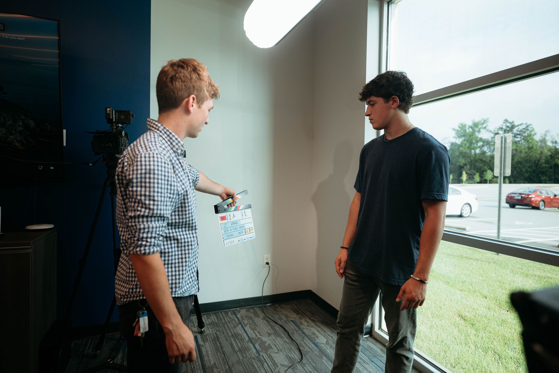Our crew holding up a slate before an interview by a conference room window