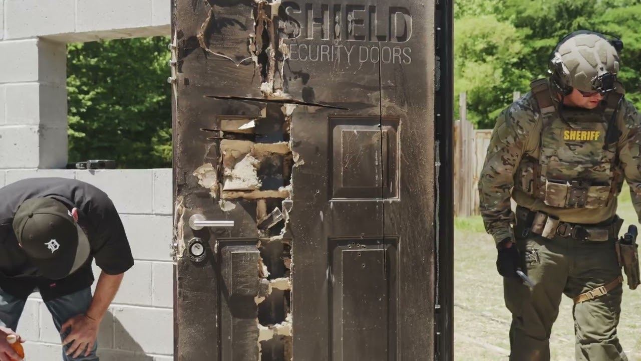 SWAT officer beside a breached Shield Security door